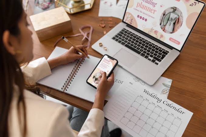 Guest relations specialist tracking RSVPs by phone against a wedding planning calendar