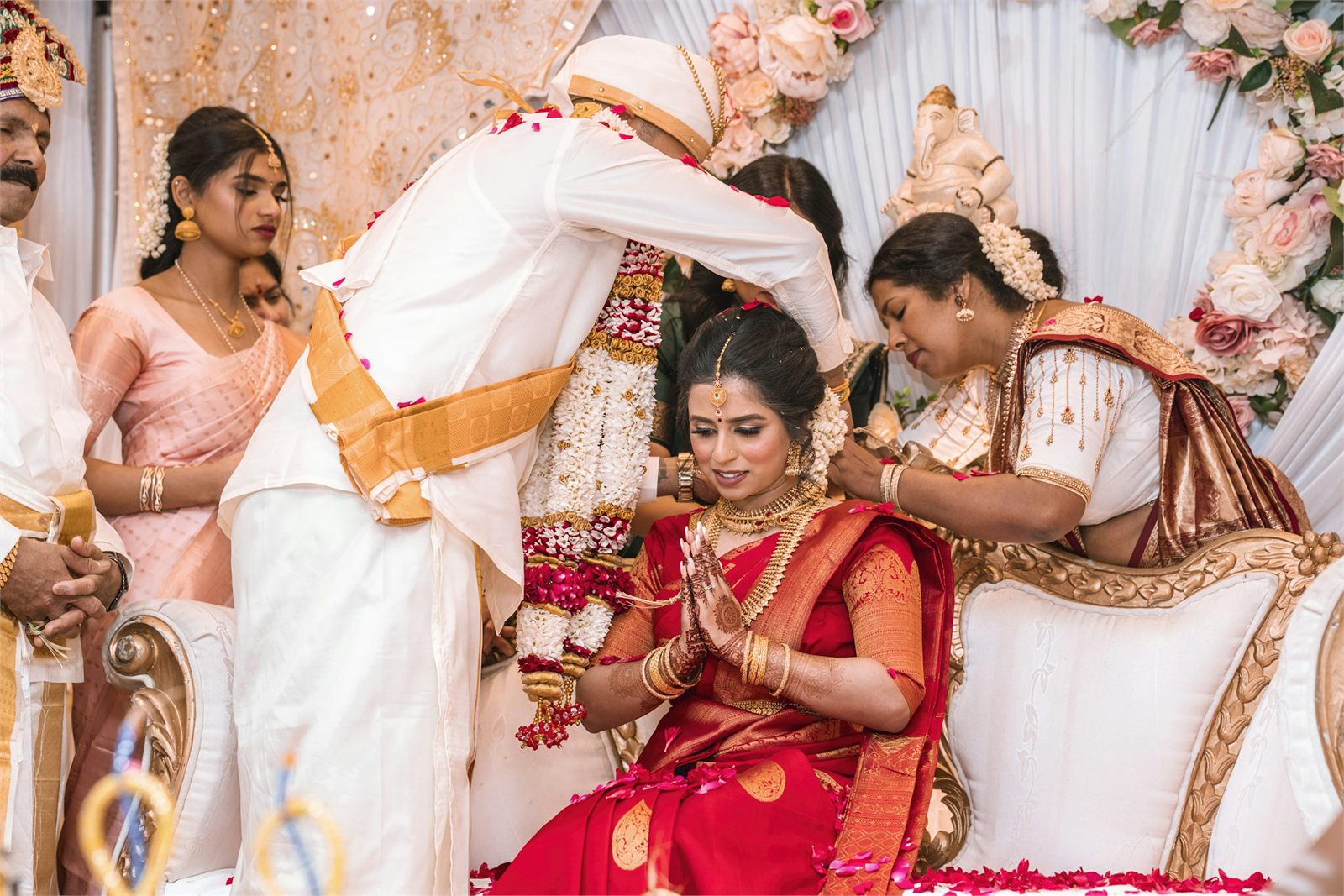 A wedding ceremony in progress, garlands being exchanged among family