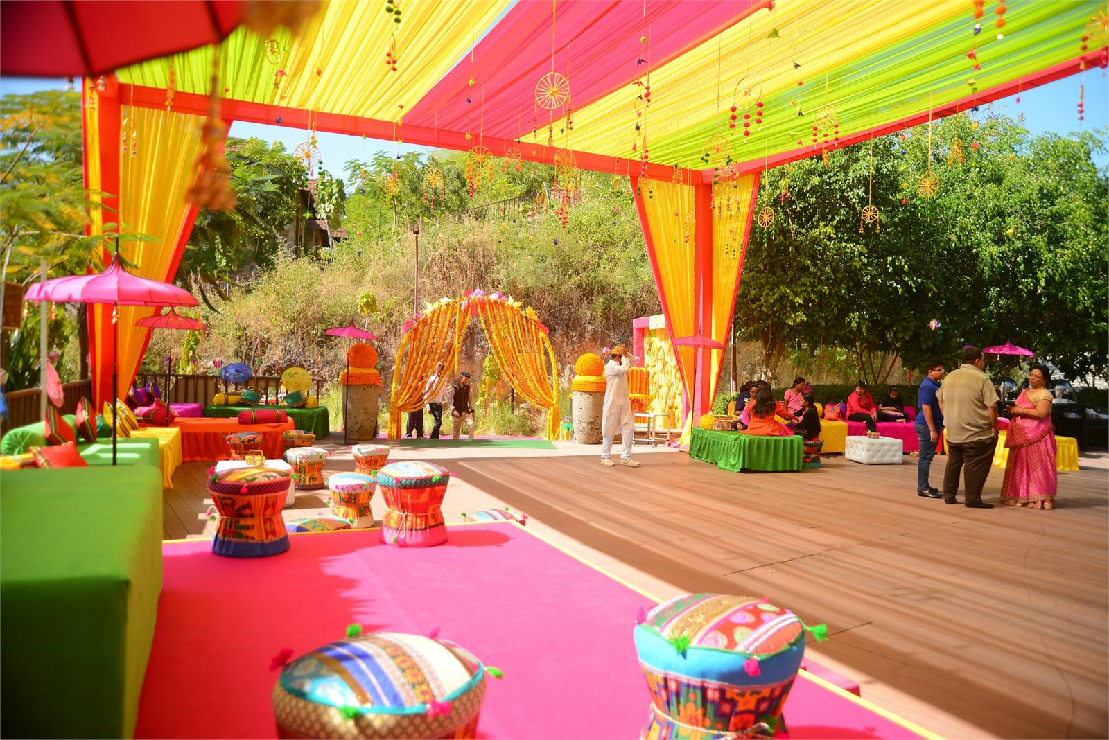 An outdoor celebration under colourful tenting and draped lighting