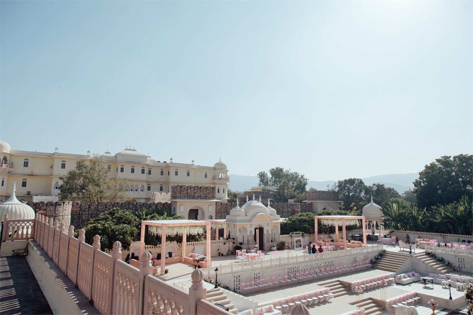 A palace courtyard set for a ceremony in flat daylight, before any guests arrive