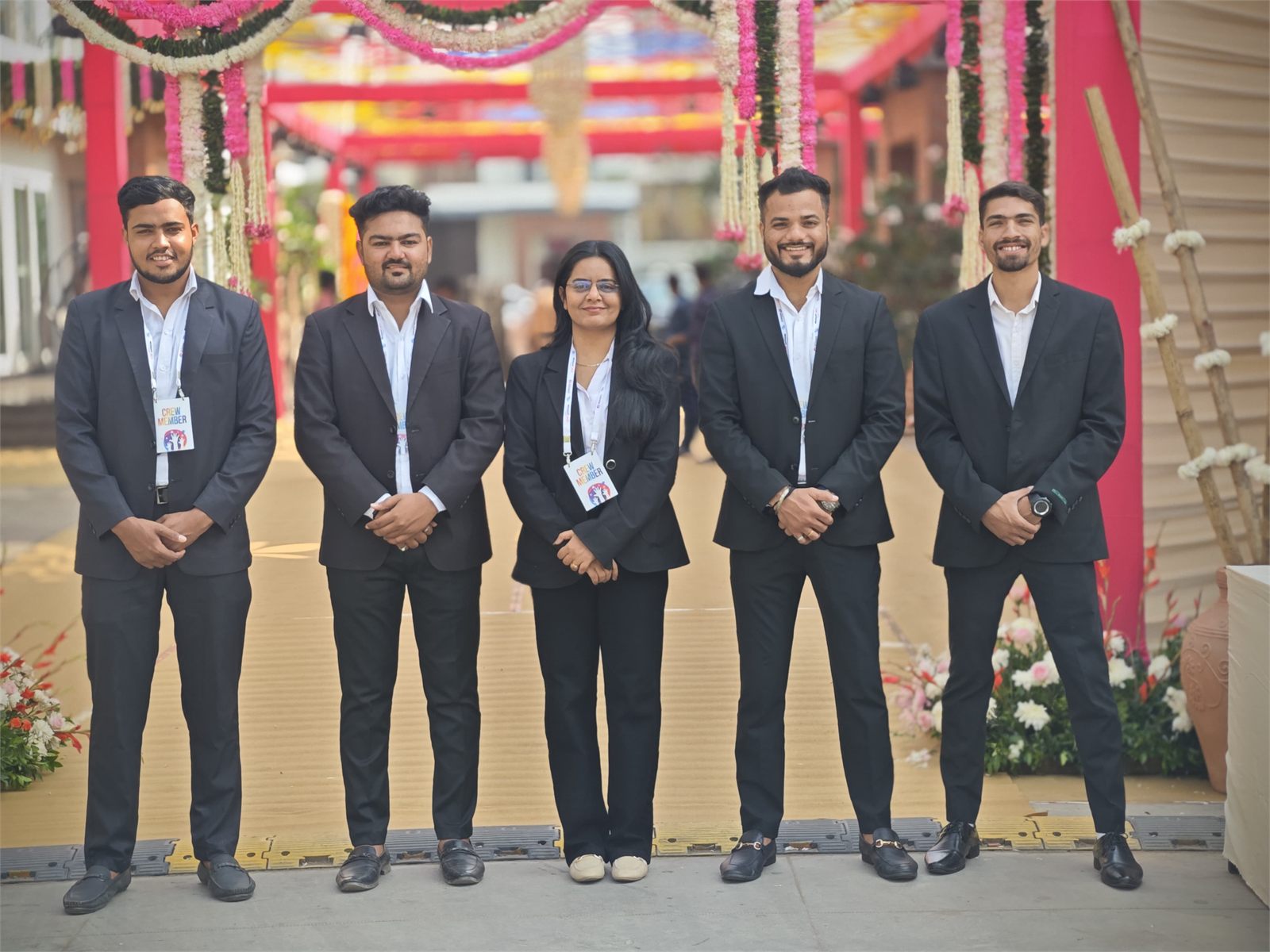 Seven Indraa Events management crew members in formal suits at a venue